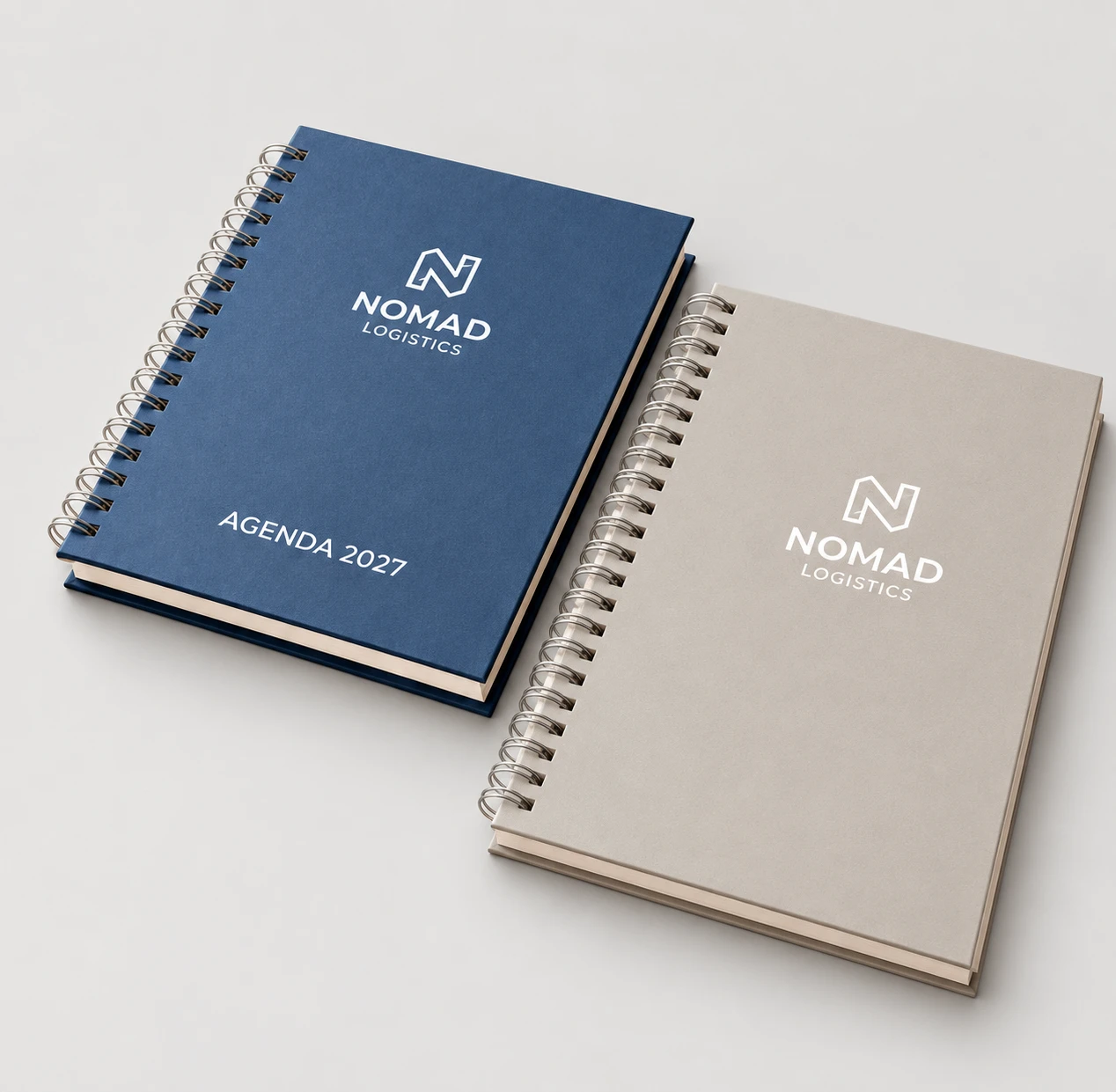 Agendas corporativas Nomad Logistics com capas azul e cinza e encadernação espiral.